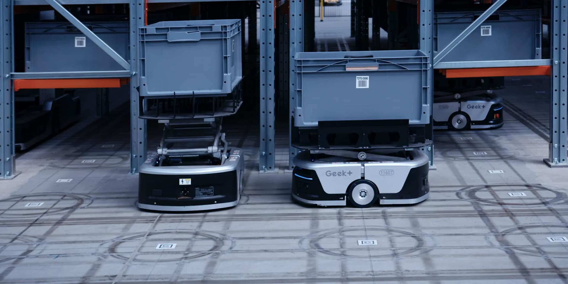 Autonomous warehouse robots moving goods between shelving units in facility