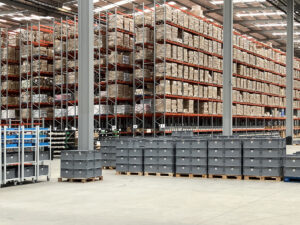 Modern 3PL warehousing facility with racks of efficient, well organised storage containing various products.