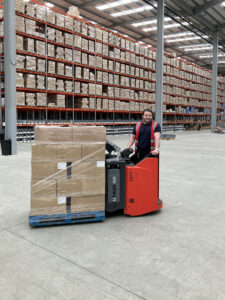 Forklift operator smiling in a modern 3PL warehousing facility 