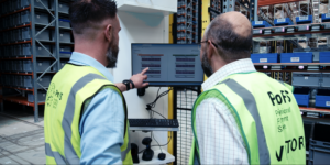 Technicians monitoring an advanced warehouse management system in a modern 3PL warehousing facility.