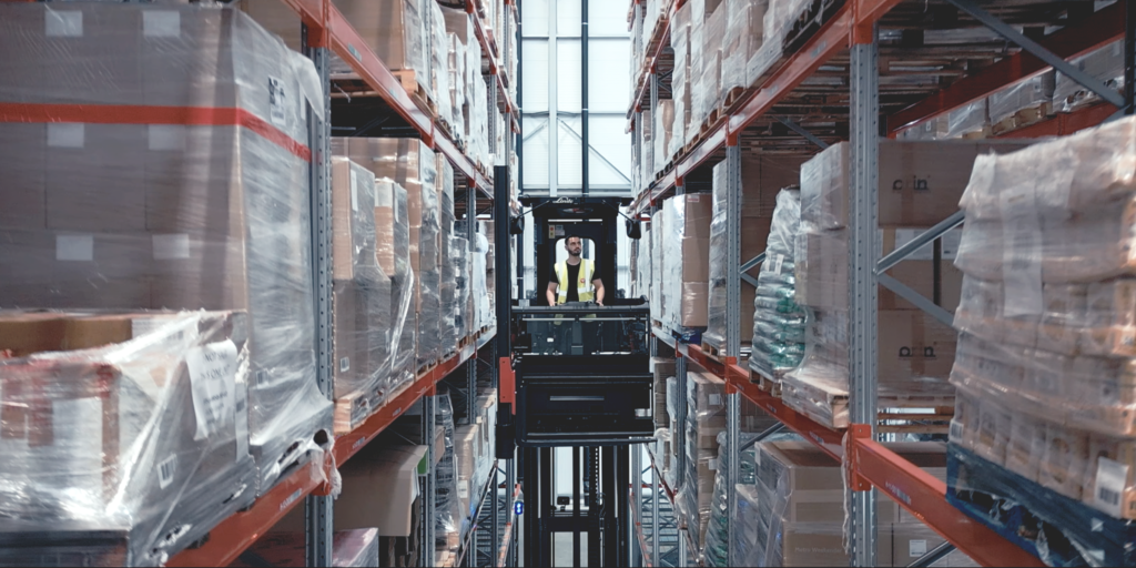 A high reach forklift in a huge, modern, 3PL warehousing facility operated by a 3PL services provider